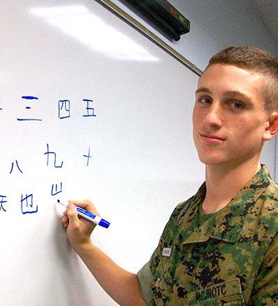 A cadet writing Chinese on the whiteboard