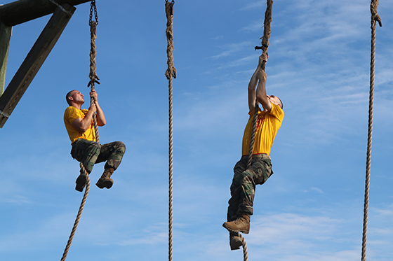 Military school plebes climbing ropes